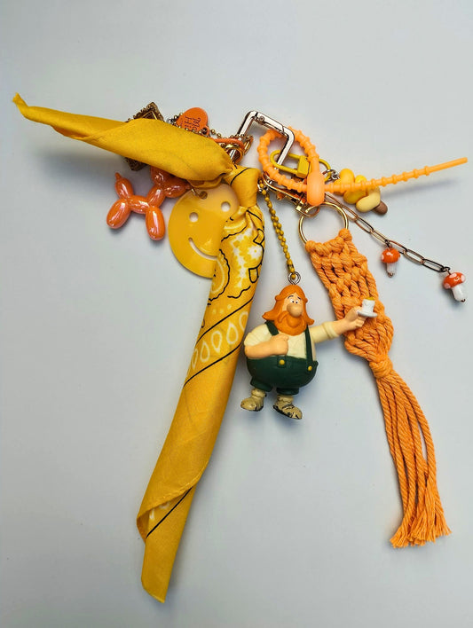 Accessoire de sac Pop et coloré orange et jaune avec macramé, pendentifs ludiques, figurine upcyclée issu de la collection/Tribu SMILE