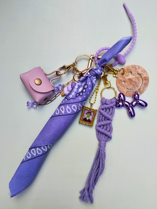 Bijou de sac élégant aux finitions dorées et violet, mini-sac, rubans de macramé et breloque délicates, modèle unique Totem Pop.