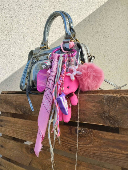 Accessoire de sac Pop et coloré avec pompon rose et pendentifs ludiques, issu de la collection/tribu Pink-Paradise