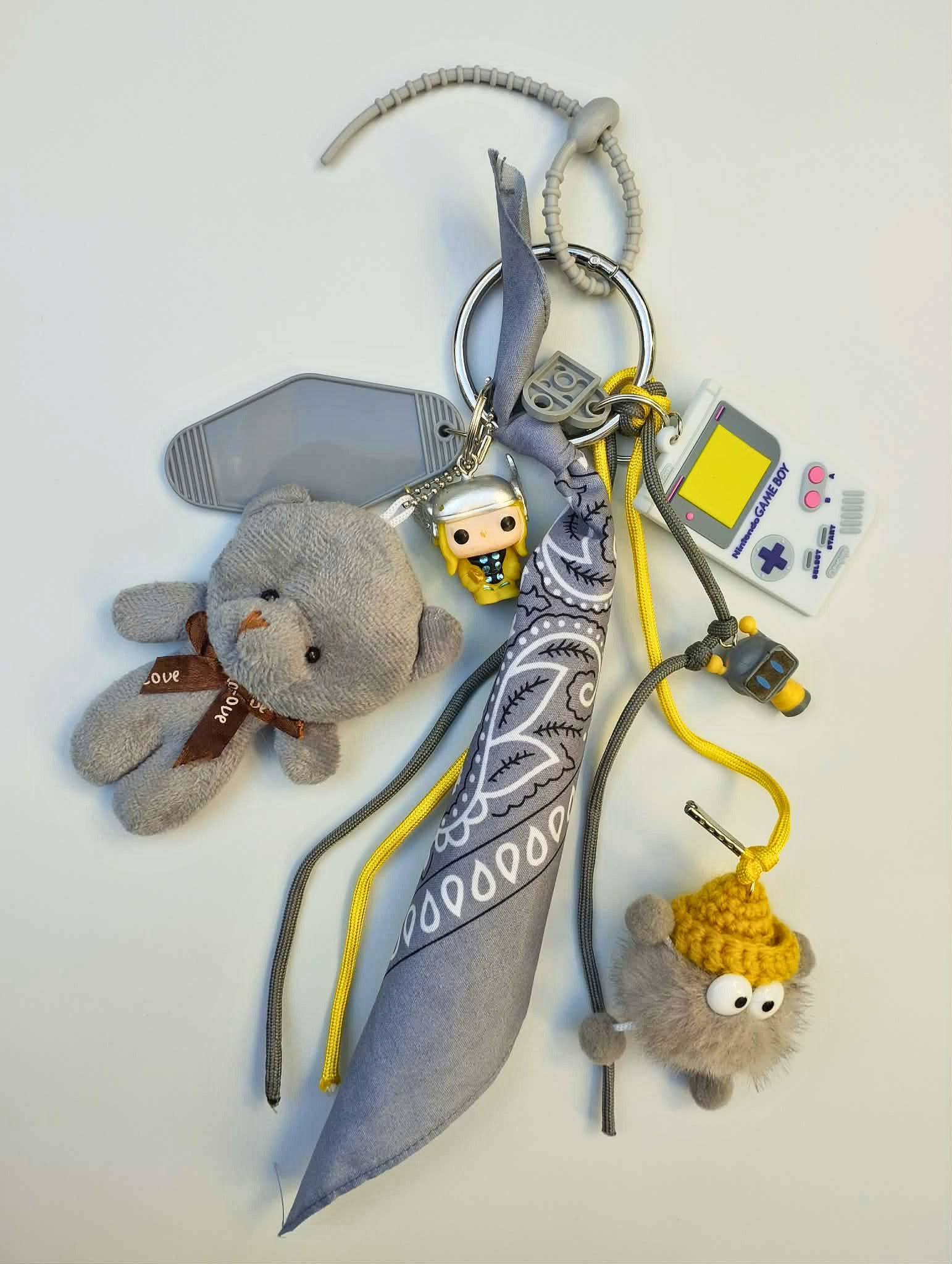 Accessoire de sac Pop et coloré avec pompon gris et jaune et pendentifs ludiques, issu de la Tribu gribouilles