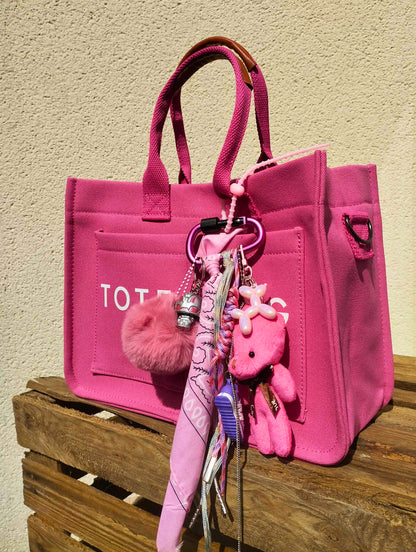 Accessoire de sac Pop et coloré avec pompon rose et pendentifs ludiques, issu de la collection/tribu Pink-Paradise